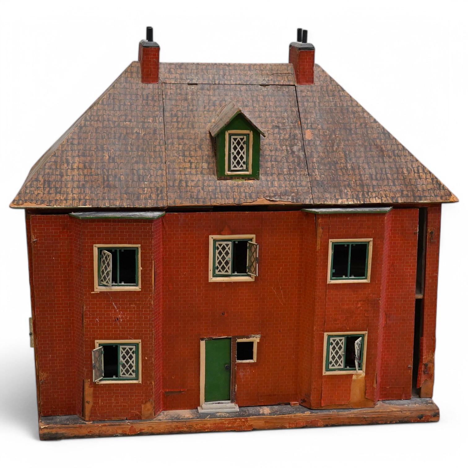 A 1920s/30s commercially produced dolls house, possibly by Tri-ang, of plywood construction, overlaid with printed paper roof tiles and brickwork, and tinplate windows and window frames, comprising of four rooms with bay